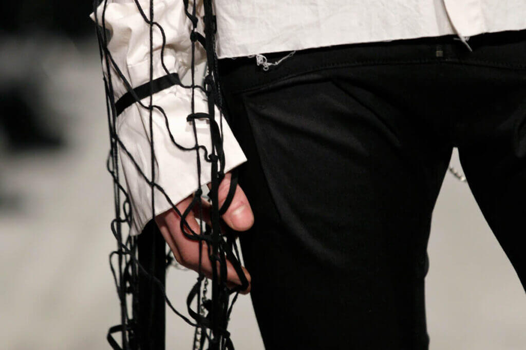 Detail of a JANBOELO shirt with a net cape from knotted leather