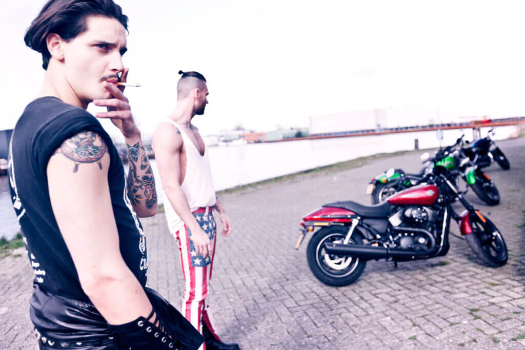 JANBOELO Fall Winter 2015 collection presentation at Paradigm Groningen, Model smoking near water with harley davidson motorcycles