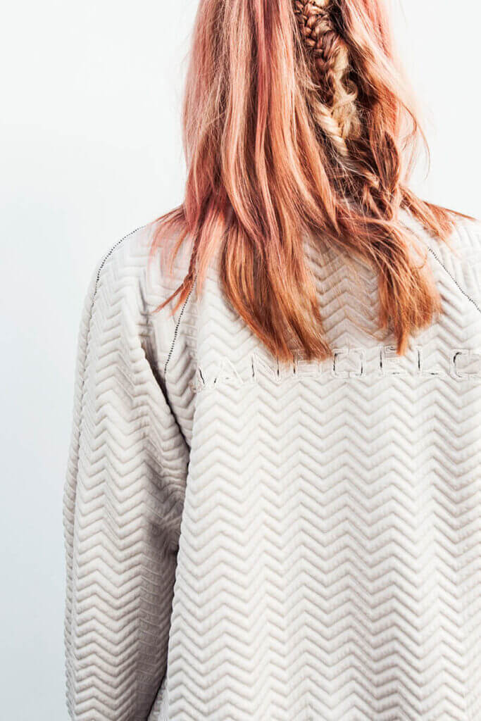 Person with pink hair, textured jacket.
