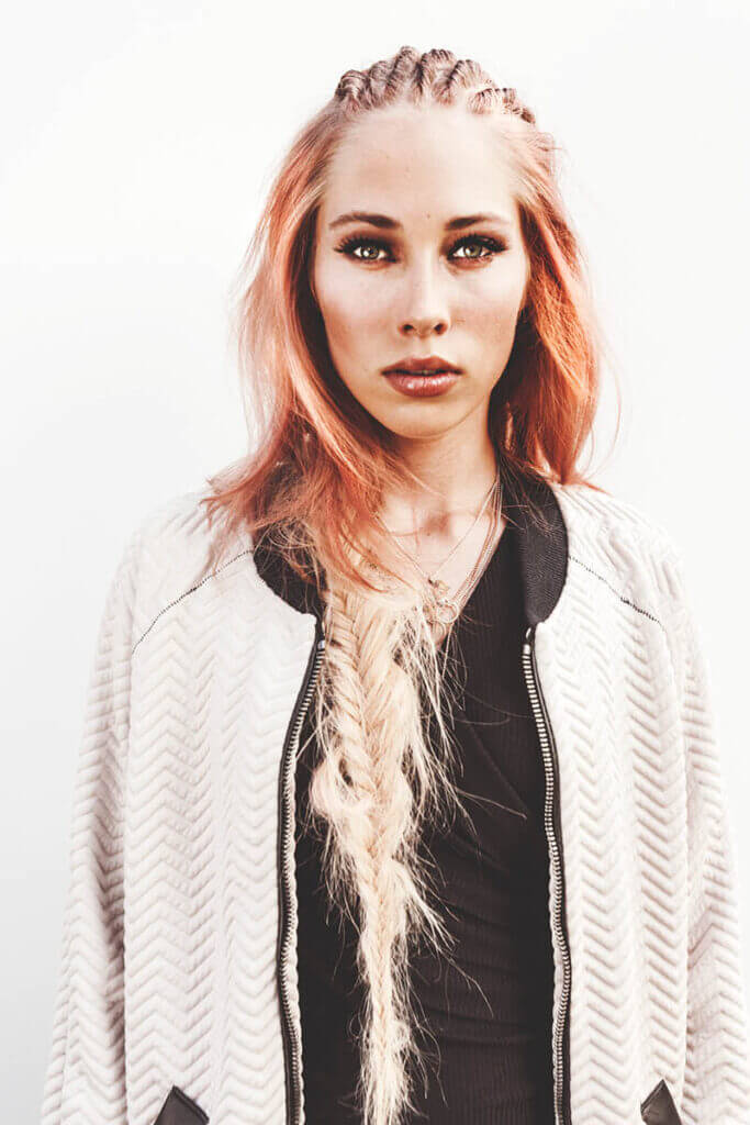 Woman with braided hair and jacket.