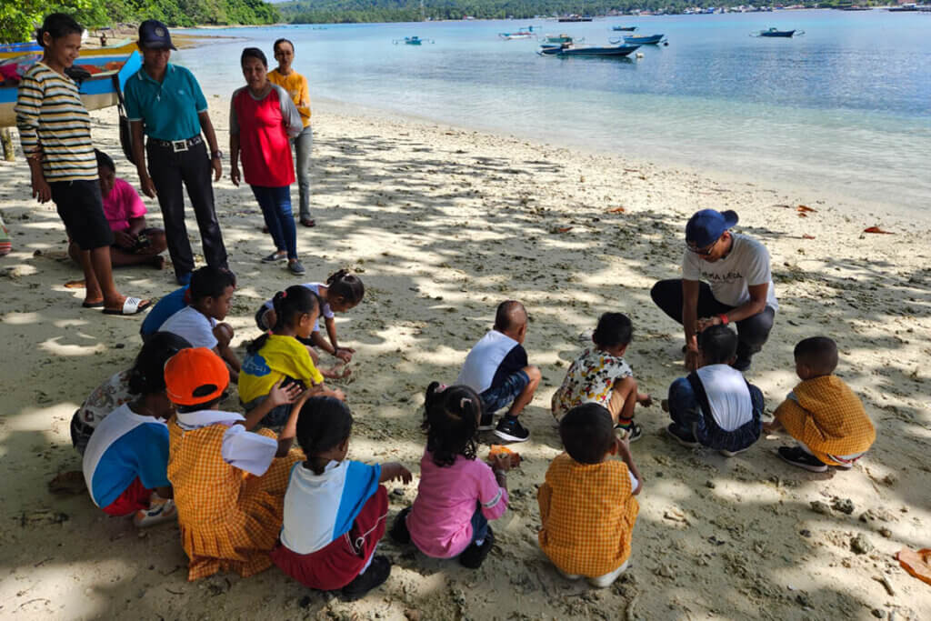 Children at the beach on Saparua Island learning about nature conservation with Heka Leka