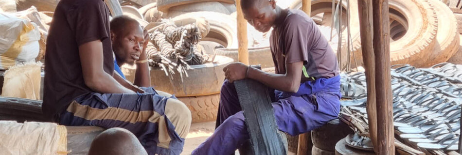 Craftsmen working in their artisan workshop in Uganda making sandals out of old tyres