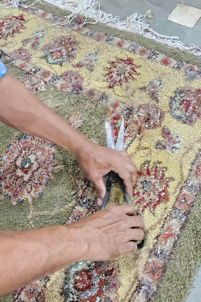 Craftsman shaping handmade tapestries inside one of the local workshops in Agra.