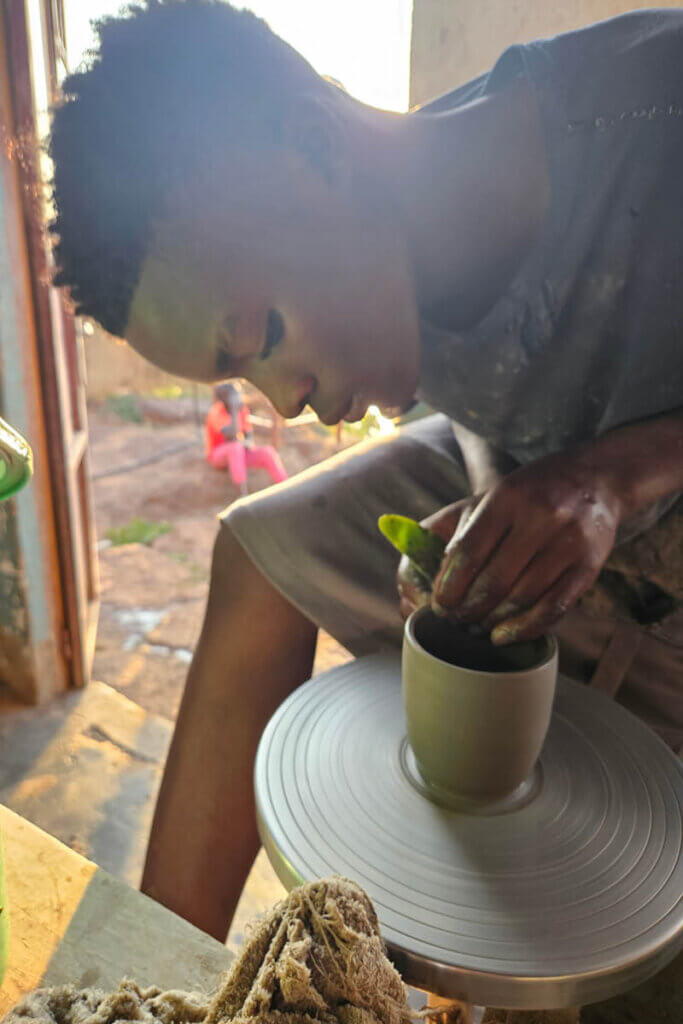 A student learns how pottery works and demonstrates how cups are made
